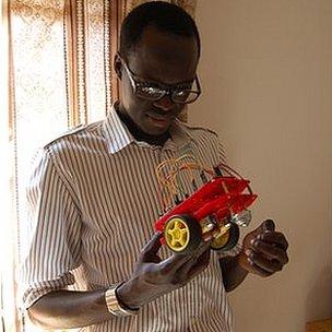 Solomon King, the founder of Fundi Bots, holds one of the kit robots they use at their robotics camps
