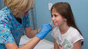 Girl being given flu vaccine nasally