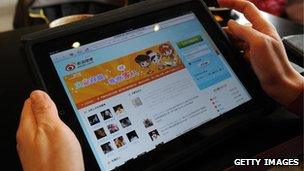 Woman holding tablet showing Sina Weibo