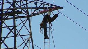 Power firm worker fixes cable