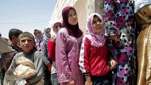 Syrians queuing outside a bakery in the town of Aldana, near Aleppo, on 31 July 2012