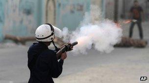 Bahrain policeman fires a tear-gas canister at a protester in Diraz (21 June 2012)