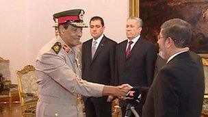Field Marshal Hussein Tantawi shakes hands with Mohammed Mursi