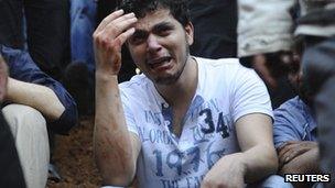 A man weeps at a mass burial in Jadidat Artouz, near Damascus, 1 August