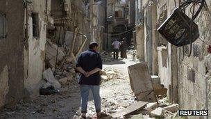 Syrian resident inspects damaged houses after shelling in Qadam, Damascus August 4, 2012