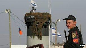 A picture taken on March 19, 2007 shows an Egyptian border policeman standing guard not far from an Israeli watch tower at the Karm Abu Salem border gate