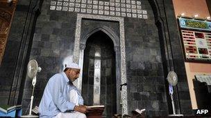 Man reading Koran in mosque in Srinagar