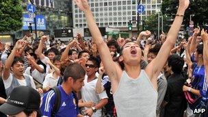 Japanese football fans in Tokyo celebrate after the women's football team won a silver medal against the US