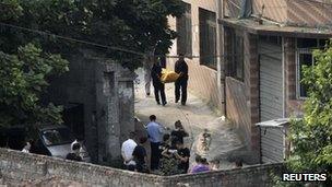 Police carrying away the body of Zhou Kehua in Chongqing