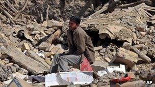 A victim of Saturday's earthquake grieves as he sits on ruins of buildings in a village near the city of Varzaqan, Iran 13 August 2012