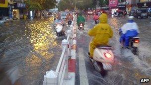 Motorists manoeuvre through a flooded street in Hanoi, Vietnam (image from 18 August 2012)