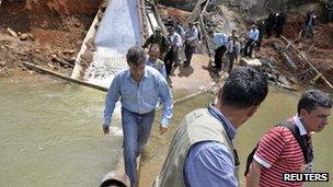 Colombian President Juan Manuel Santos visits the scene of a rebel attack in Caqueta province