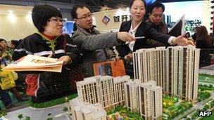 Buyers looking at a model of a new home development in China