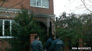 Emergency workers stand outside the house where the murdered occurred (file image from 2010)