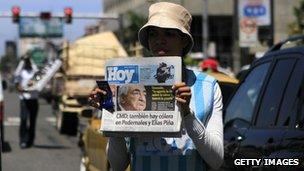 A newspaper seller displays a copy of the Dominican newspaper Hoy in Santo Domingo