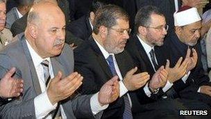 Egypt's President Mohammed Morsi (C) takes part in Eid al-Fitr prayer with Vice President Mahmoud Mekky (L) and members of the government in Cairo