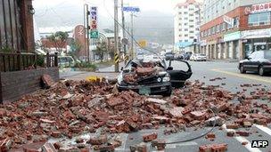 Fallen bricks lie next to a destroyed car in Wando, South Korea, after Typhoon Bolaven hit on 28 August 2012