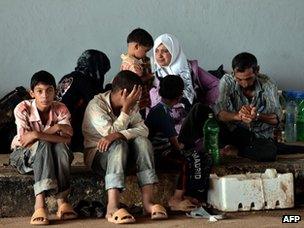 A Syrian family wait to be allowed to cross the Syria-Turkish border (27 August 2012)