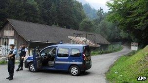 French gendarmes block the road leading to the scene where four people died near Annecy Lake, eastern France, on Wednesday