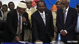 President Hassan Sheikh Mohamud (c) with his hand on the Koran