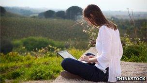 Woman uses laptop in countryside