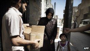 Woman receives food parcel in Aleppo