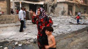 Woman and child running through street after air strike in Aleppo, Syria