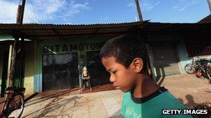Boy walking down street in rural Brazil