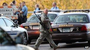 An officer walks through the area as police investigate a shooting at Accent Signage Systems on the north side of Minneapolis on 27 September 2012