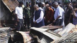 Mohiuddin Khan Alamgir (C) visits a burned temple in Cox's Bazar September 30