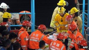 Rescue workers carry a victim ashore after a ferry collided with a tug boat off Hong Kong on 1 October, 2012