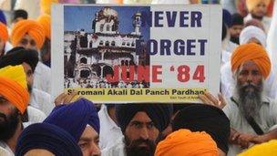 An activist from a radical Sikh organization holds a poster showing the 1984 damage of the Sri Akal Takht at the Golden Temple in Amritsar on June 6, 2009.