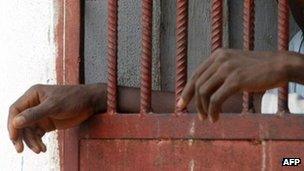 The hands of inmates seen through prison bars in Liberia (Archive shot)