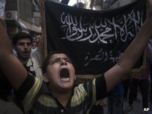 People hold up the flag of the al-Nusra Front at a protest in Aleppo (21 September 2012)