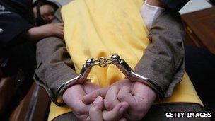 File photo: A crime suspect being handcuffed in China