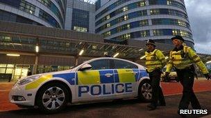 Police patrol the emergency entrance to Queen Elizabeth Hospital in Birmingham (15 Oct 2012)