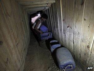 A man smuggles goods under the Gaza-Egypt border (30 September 2012)
