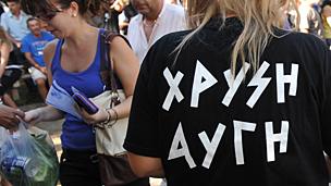Golden Dawn members (R) hand out free food to Greek people after checking their IDs