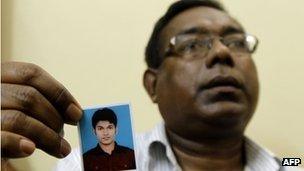 Quazi Mohammad Ahsanullah holds a portrait of his son in Dhaka, Bangladesh 18 October 2012