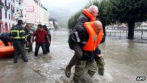 A rescuer carries a man on his back in Lourdes. Photo: 20 October 2012