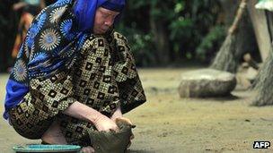 An albino woman in Tanzania moulding a pot from clay in Ukerewe, an island on Lake Victoria, near the town of Mwanza - January 2009