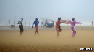 Women shield their faces during strong winds at Marina beach in the southern Indian city of Chennai October 31, 2012