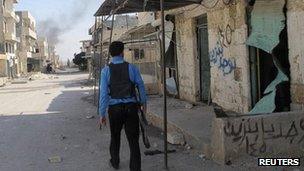 A Free Syrian Army fighter patrols a street in the Taftanaz, 3 Nov