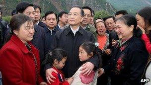 Wen Jiabao (C) consoles the families who survived the massive earthquake in Beichuan, southwest China's Sichuan province, 14 May 2008