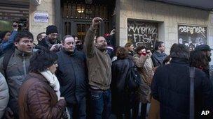 Demonstrators against evictions block the door to a house in Madrid