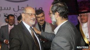Haitham al-Maleh (left) shakes hands with Moaz al-Khatib in Doha (11 November 2012)