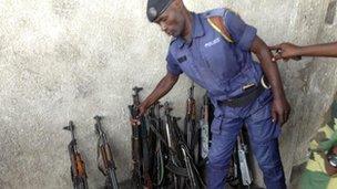 Goma policeman deposits his gun next to a rebel (Photo Gabriel Gatehouse)