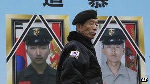 A South Korean veteran stands in front of portraits of two marines killed on Yeonpyeong island, at a rally in Seoul on 22 November 2012