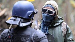 A riot policeman confronts a masked protester at the proposed site of the new airport on Saturday