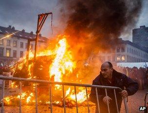 A farmer moves a barrier as a trailer burns in Brussels, 26 November